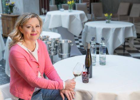 Natalie Lumpp sitzt mit einem Weinglas am Tisch